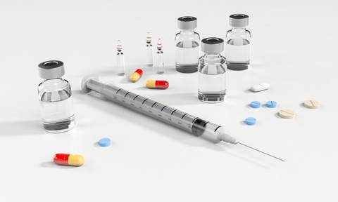 Drug vials, pills, and syringe with needle to portray heartworm treatment